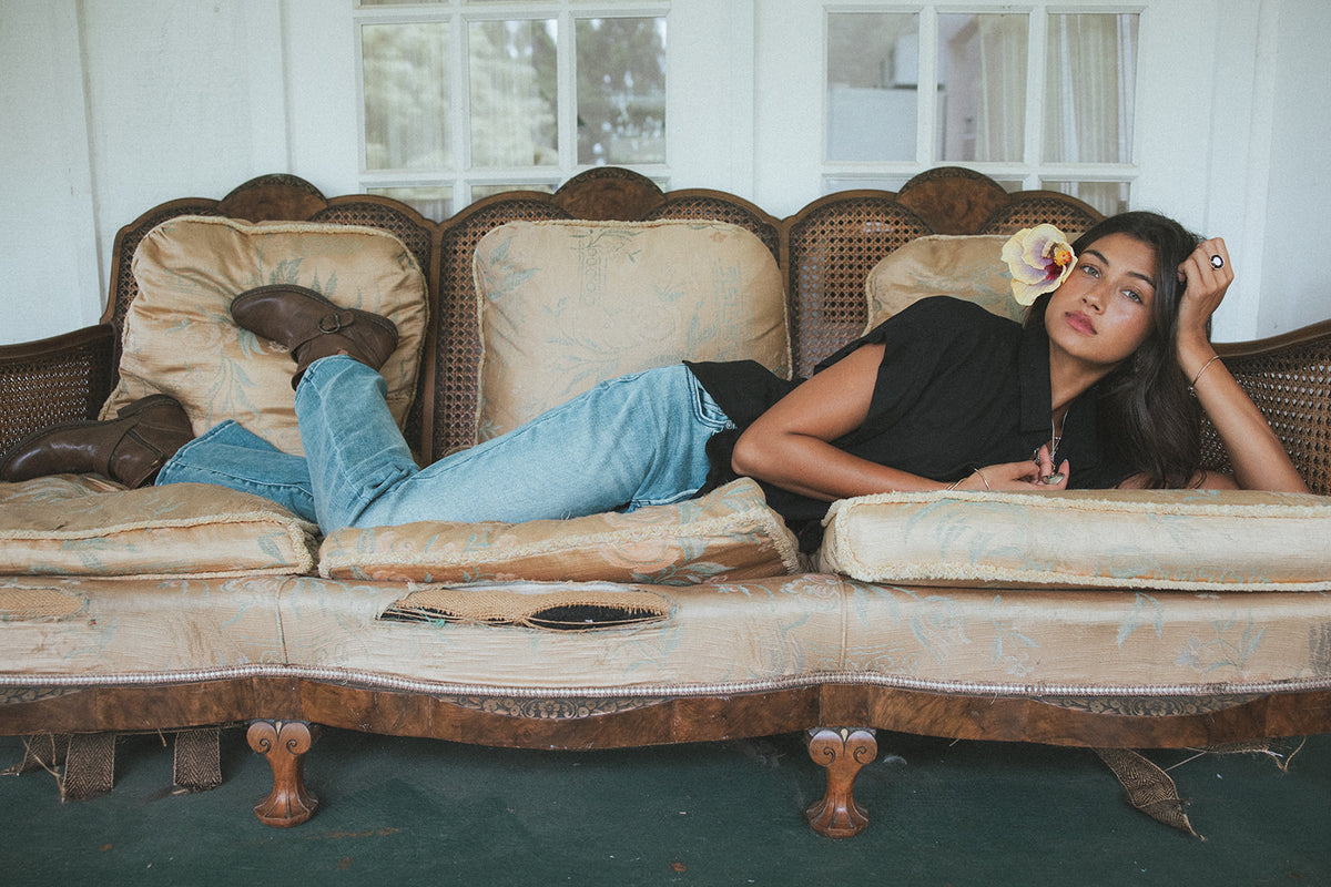 Model lounging on a vintage sofa