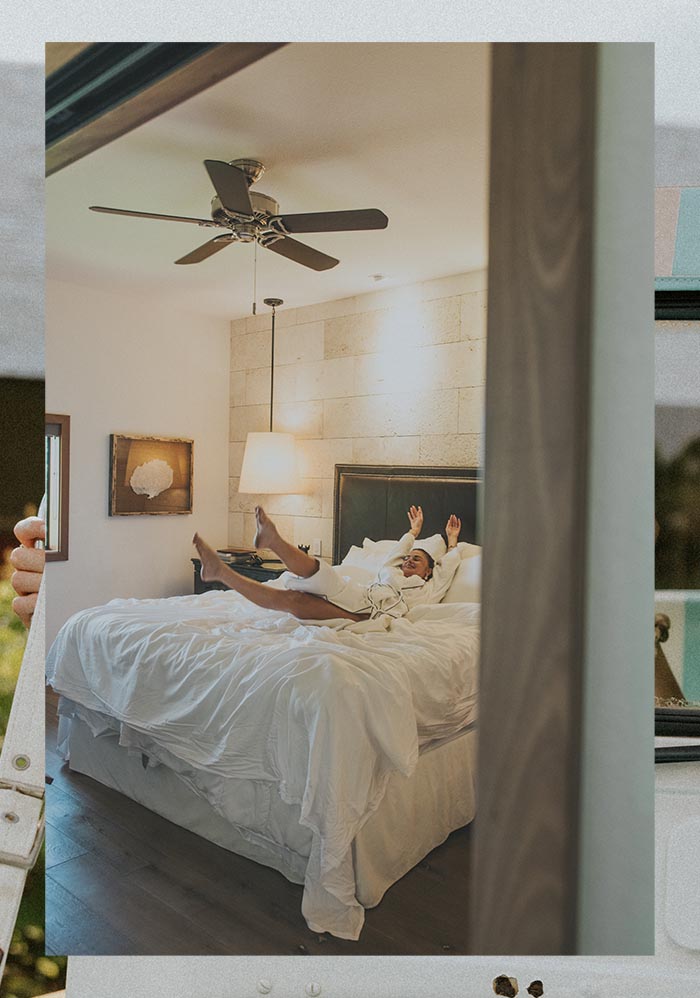 Model lying across the bed in a hotel room