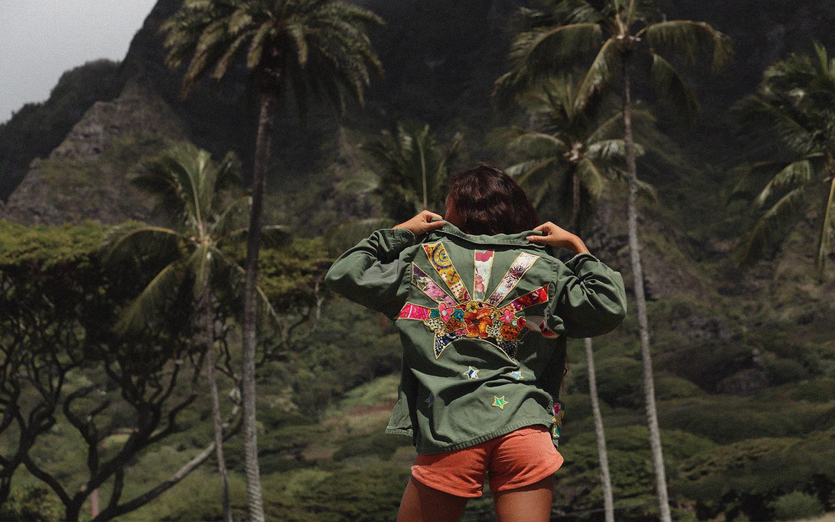 Back of an embroidered green jacket against the mountains