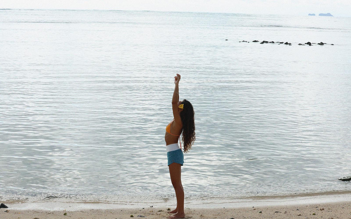 Model at the water's edge reaching up