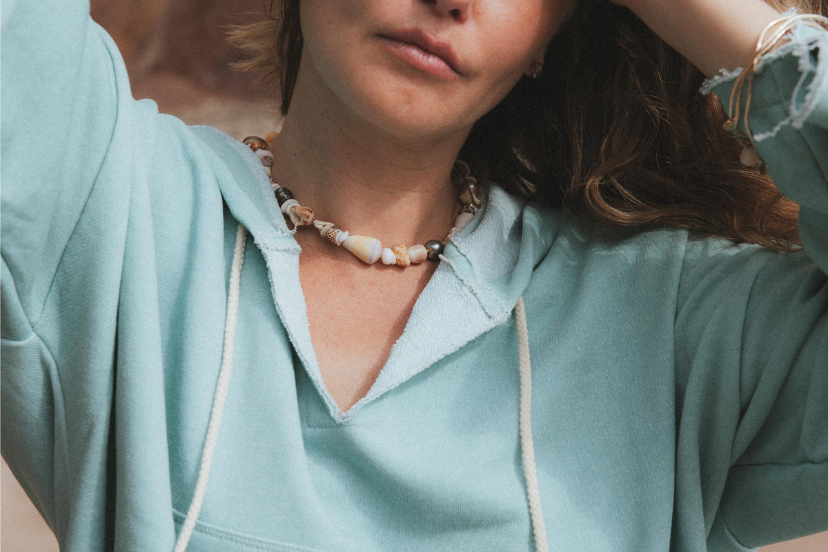 Shell lei necklace on a mint hoodie