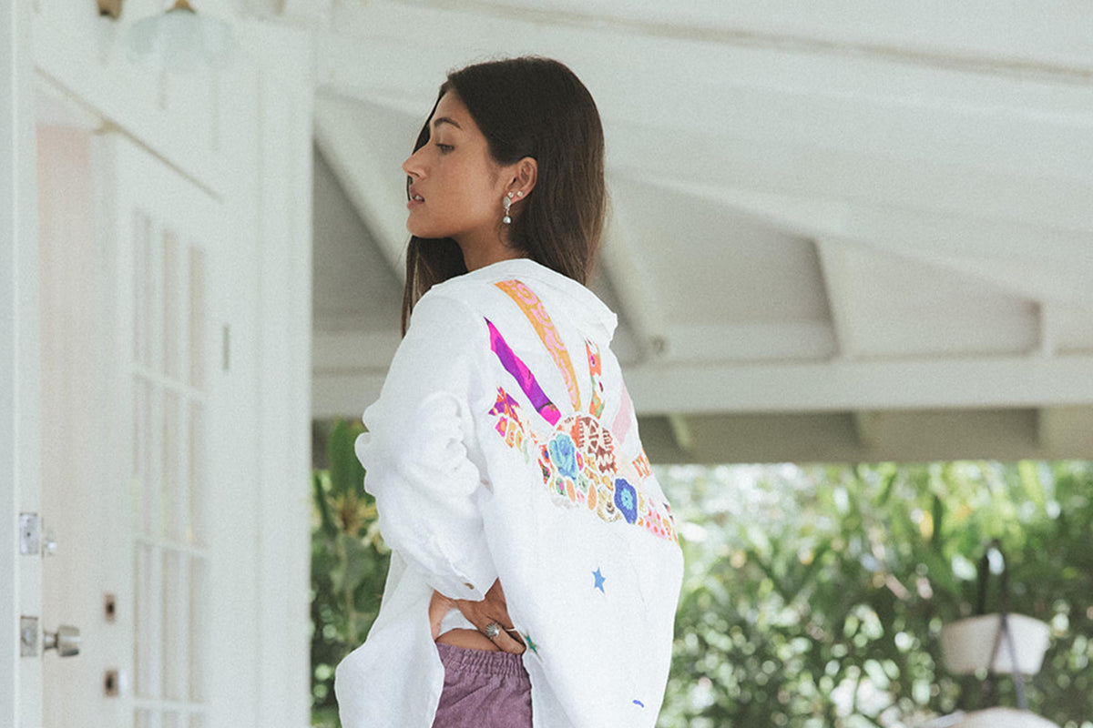 Back of a white jacket with embroidered patches on the porch