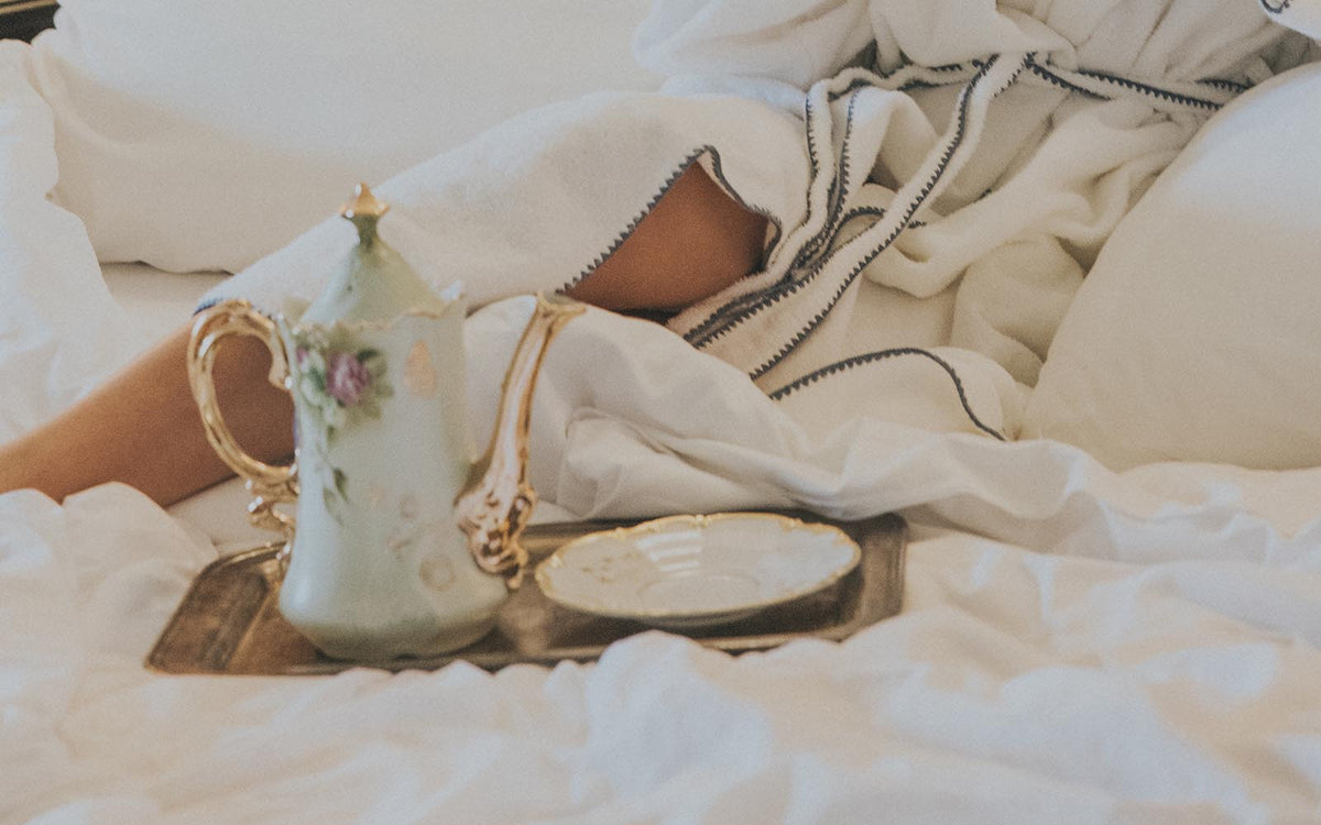 Teapot and cup on a white bed