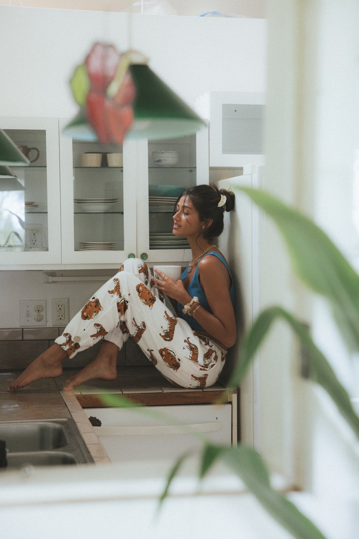 Model in a tiger print set sitting by a window