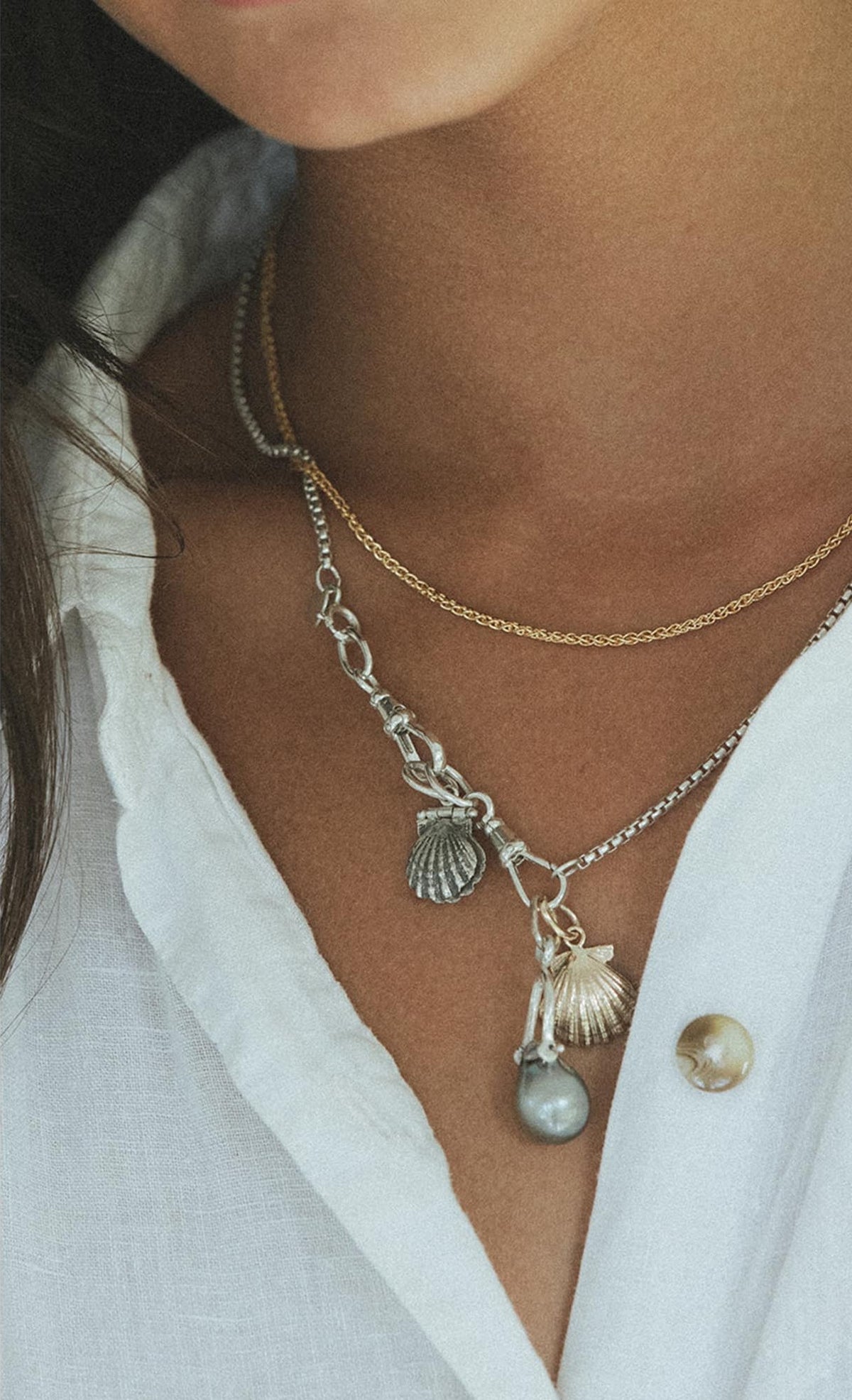 Charm necklace over a white shirt