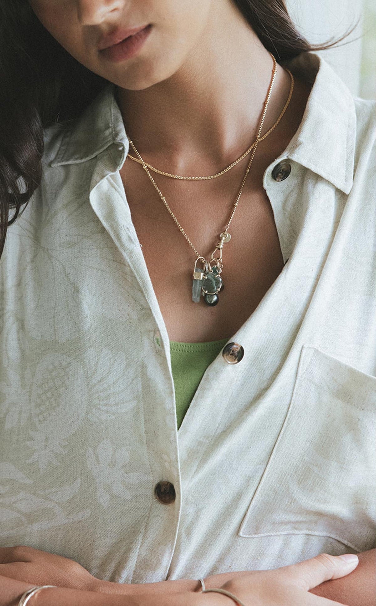 Model in a white shirt wearing a charm necklace