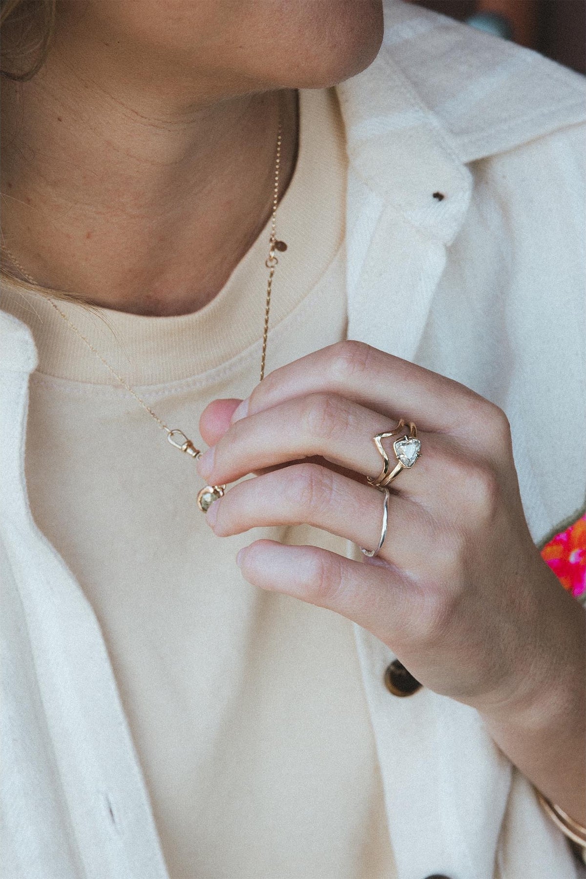 Hand with a diamond ring against a white shirt
