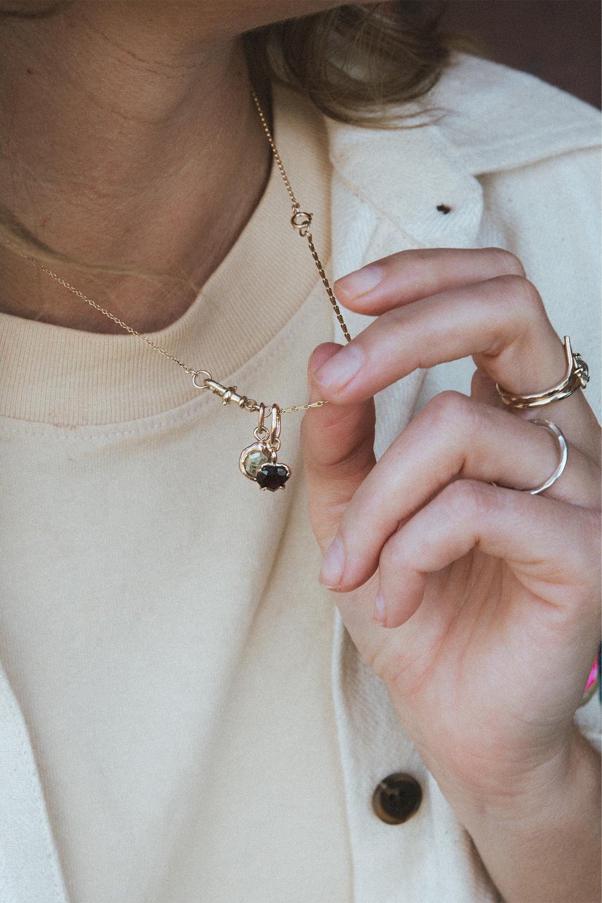 Hand with rings at the collar of a white shirt