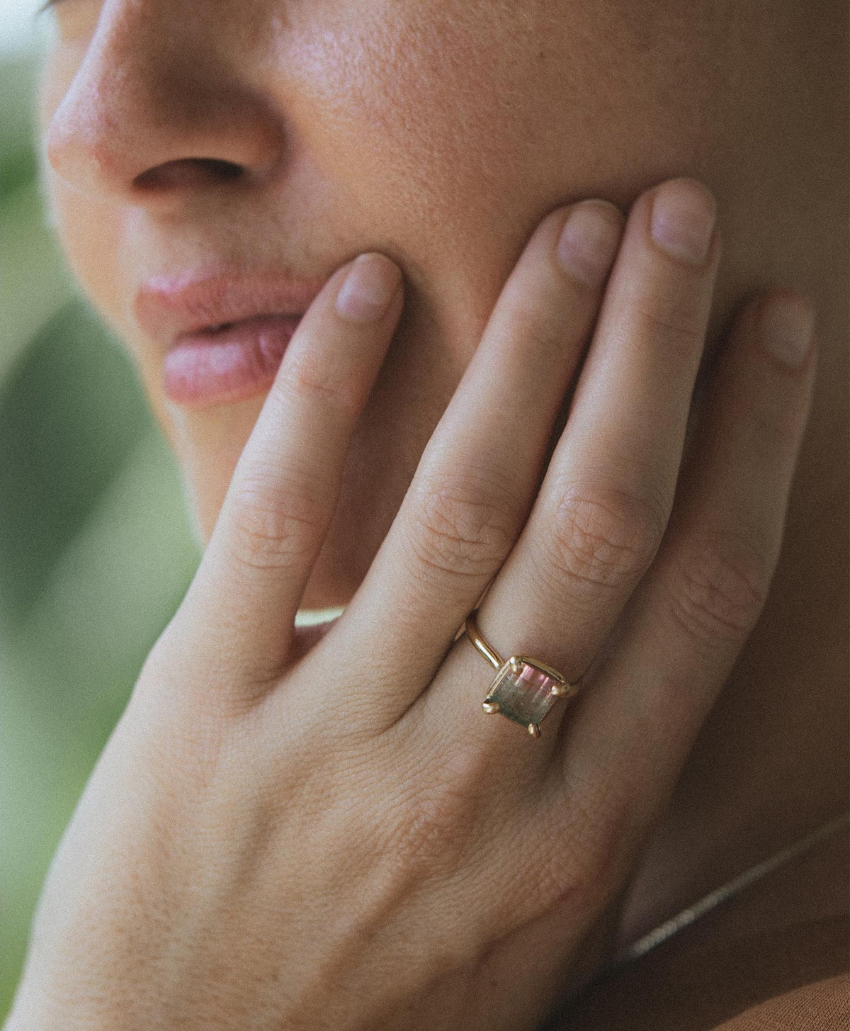 Hand with a ring at the cheek
