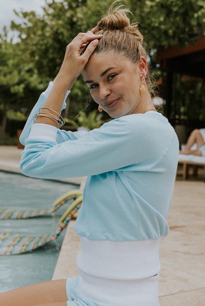 Model in a pale blue sweater by the pool