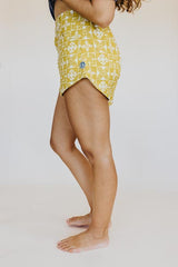 Model wearing Wings Hawaii retro pocket shorts in quilted ulu and plumeria print in marigold thumbnail