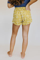 Model wearing Wings Hawaii retro pocket shorts in quilted ulu and plumeria print in marigold thumbnail