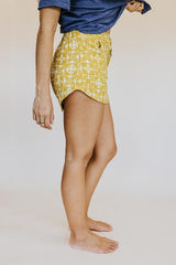 Model wearing Wings Hawaii retro pocket shorts in quilted ulu and plumeria print in marigold thumbnail