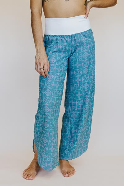 Model wearing Wings Hawaii pau hana pants in quilted ulu and plumeria print in surf blue - front