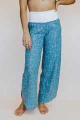 Model wearing Wings Hawaii pau hana pants in quilted ulu and plumeria print in surf blue - front thumbnail