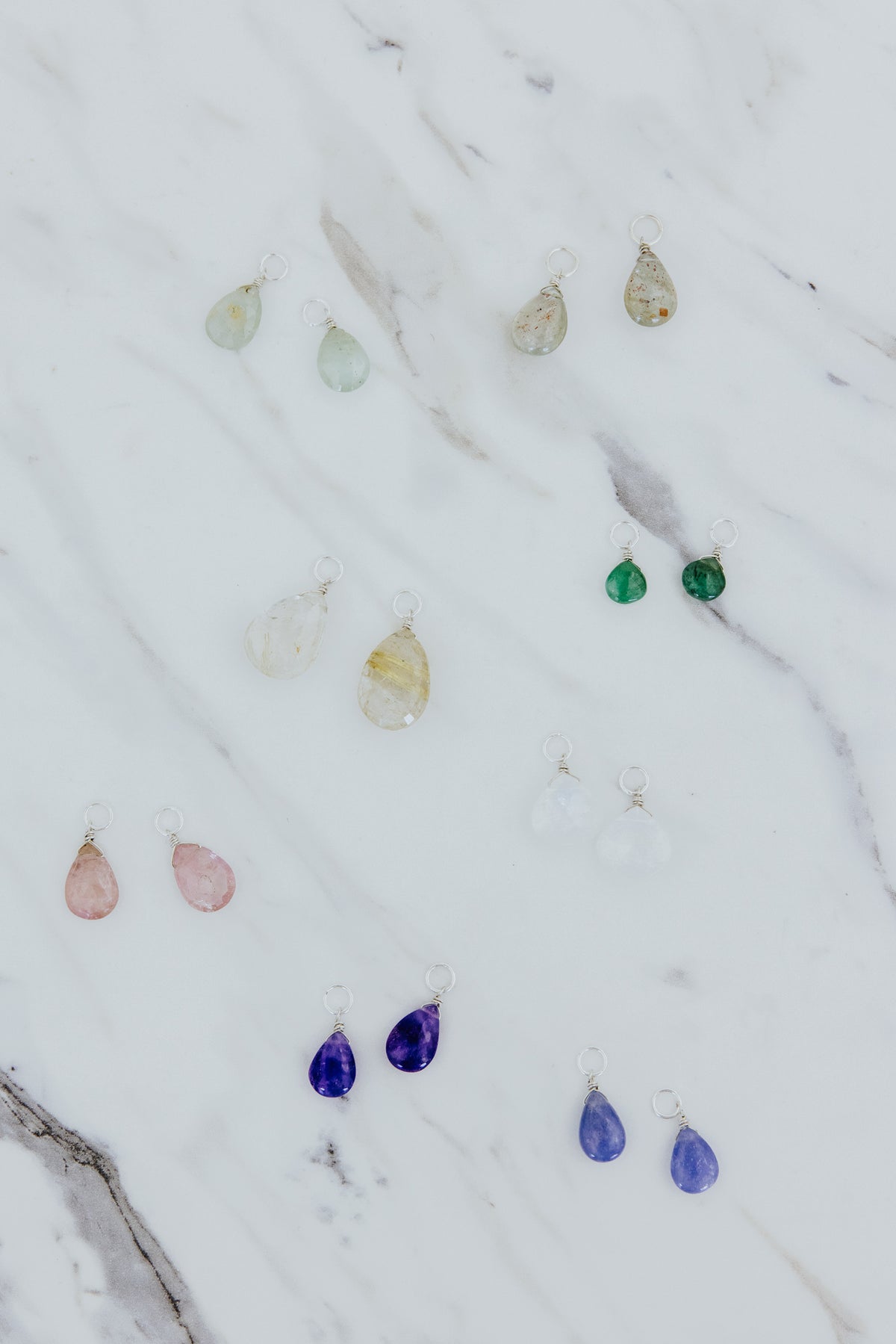 Wings Hawaii gemstone earring charms in sterling silver. Fine jewelry handcrafted in Maui. Varieties include Aquamarine, Black Sapphire, Emerald, Hackmanite, Herkimer, Labradorite, Moonstone, Pink Tourmaline, Peridot, Rutilated Quartz, or Sunstone. Made for Charm Bar mix match customize create your own designer luxury charm hoop earrings. 