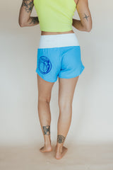 Wings Hawaii best-selling pau hana shorts in hibiscus blue + starmaid. Tropical floral and mermaid print designed in Maui. Modern beachy loungewear. Small batch, sustainable women's apparel from Paia, Maui.  thumbnail