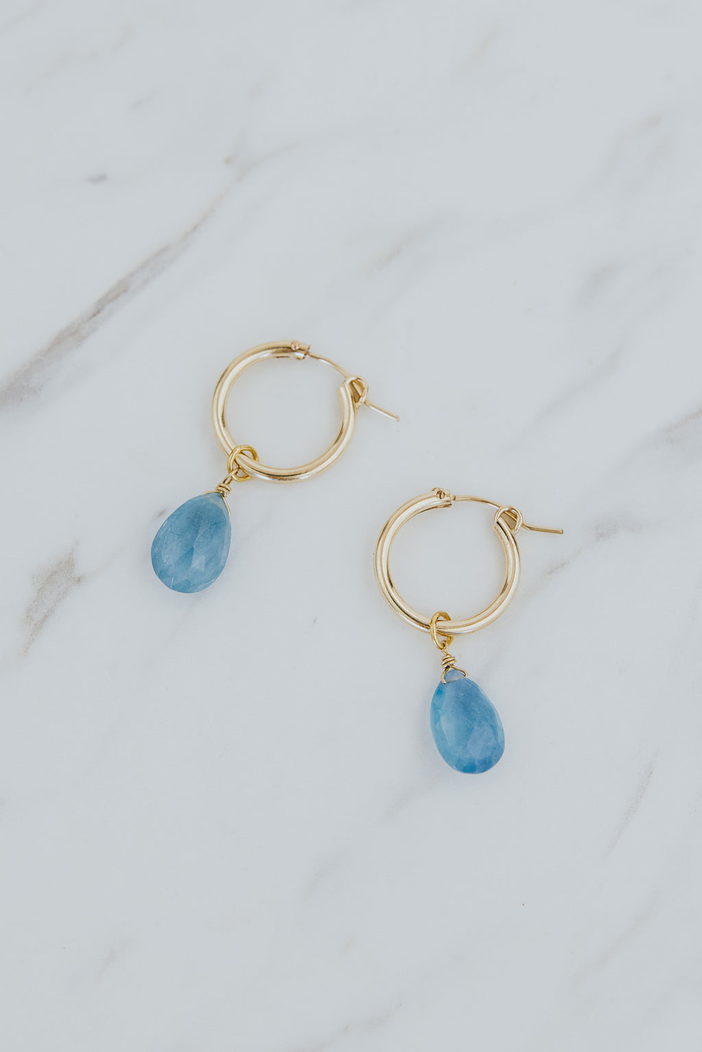 Wings Hawaii faceted aquamarine charms in 14k gold filled shown on hoop earrings. Fine jewelry handmade in Maui. Modern, elevated charm earrings to mix, match, customize.