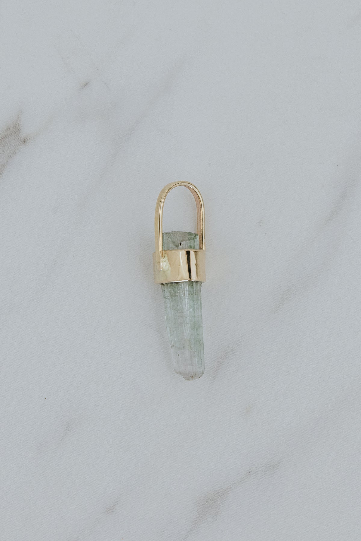 Wings Hawaii raw tourmaline necklace charm in solid 14k yellow gold. Aqua blue-green gemstone with raw cut. Earthy, boho fine jewelry handcrafted in Maui. 
