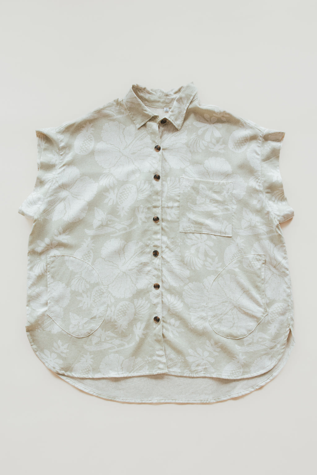 Wings Hawaii women's Short Sleeve Pocket Blouse in beige Hana Pearl muted aloha print. Designed in Maui, made in Bali. Elevated, chic aloha wear sustainably handcrafted in small batches. 