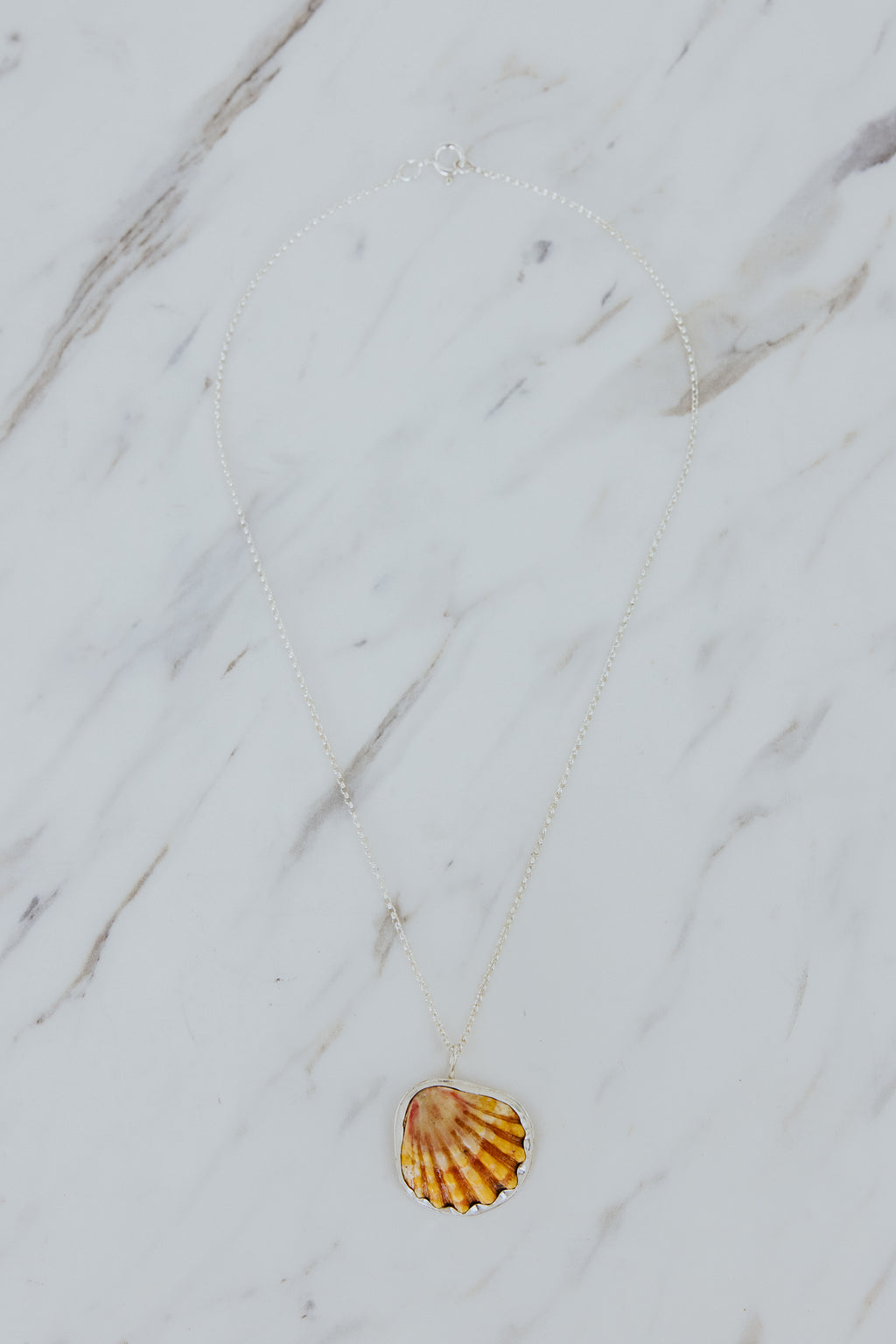 Wings Hawaii bezel-set Sunrise Shell necklace. Authentic, rare Hawaiian beach shell on sterling silver chain necklace. Fine jewelry handmade with aloha on Maui. One of a kind gifts made in Hawaii.