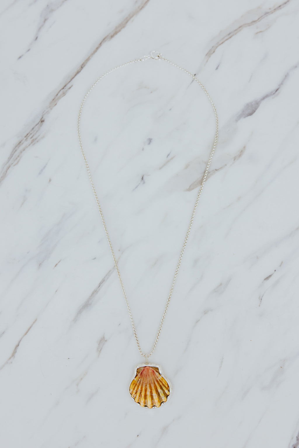 Wings Hawaii bezel-set Sunrise Shell necklace. Authentic, rare Hawaiian beach shell on sterling silver chain necklace. Fine jewelry handmade with aloha on Maui. One of a kind gifts made in Hawaii.