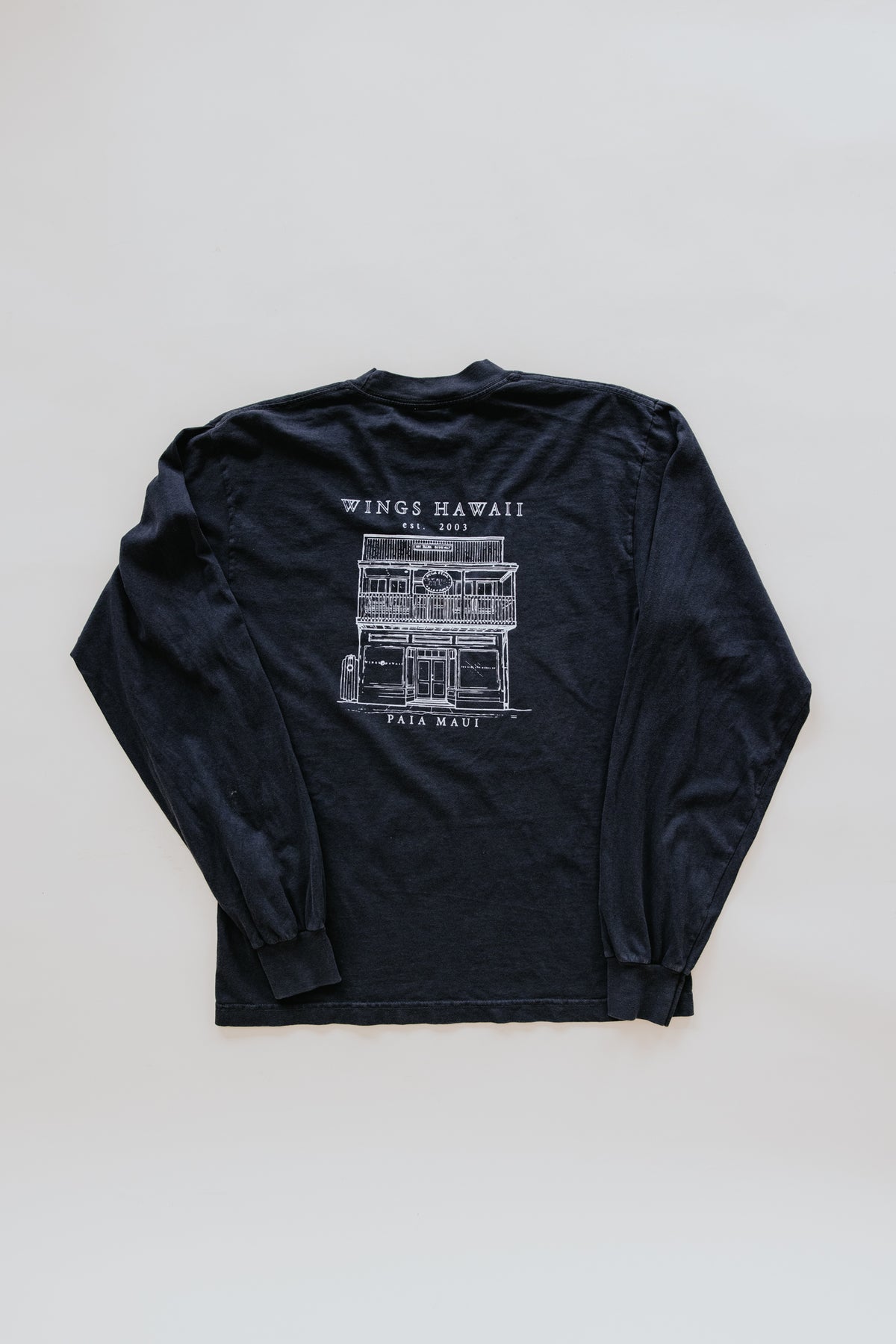 Wings Hawaii men's long sleeve tee in black. Wings 1981 design on front, Wings Hawaii Paia Store on back. Original artwork designed in Maui. Paia, Maui men's souvenir t-shirts. 