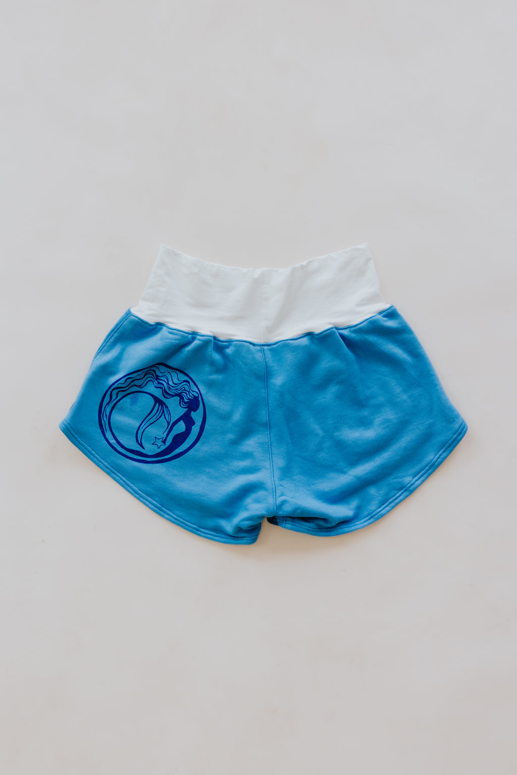 Wings Hawaii best-selling pau hana shorts in hibiscus blue + starmaid. Tropical floral and mermaid print designed in Maui. Modern beachy loungewear. Small batch, sustainable women's apparel from Paia, Maui. 
