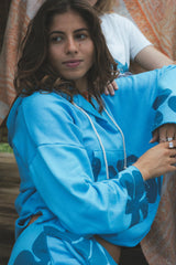 Wings Hawaii beach hoodie in blue crush hibiscus print. Designed in Maui, sewn in Bali. Cozy french cotton terry, drawstring hood, front kangaroo pouch, wide sleeves. Coastal chic surfer girl vibes.  thumbnail