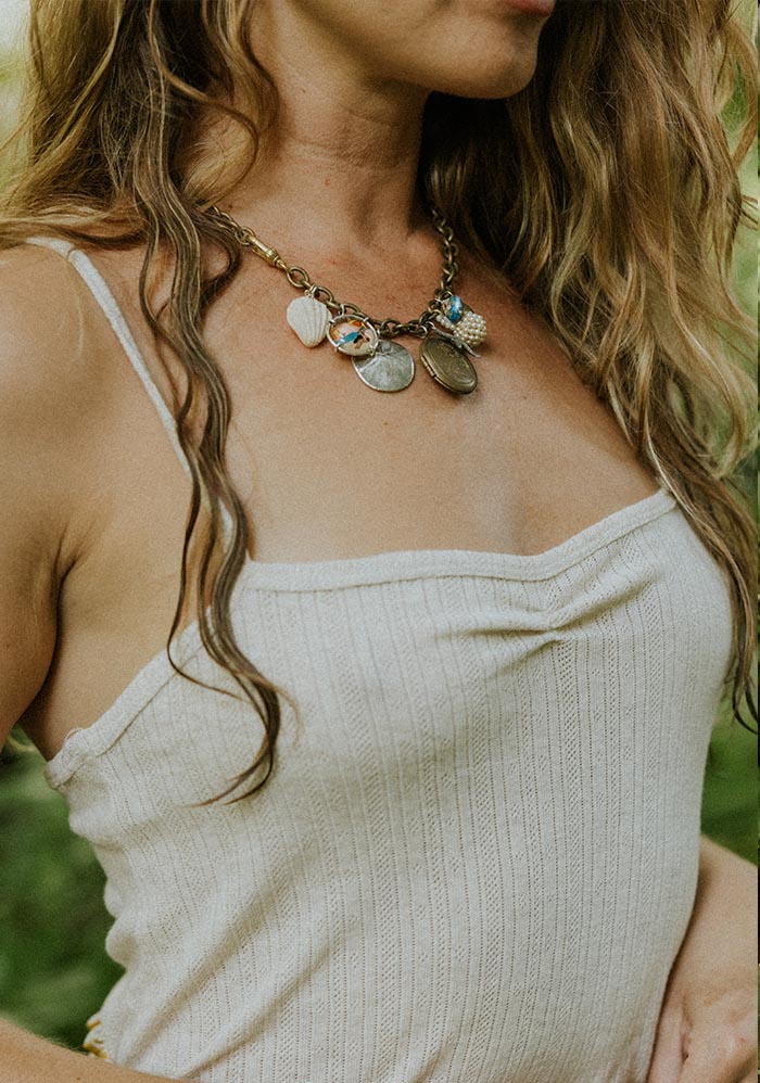 Charm necklace over a cream camisole