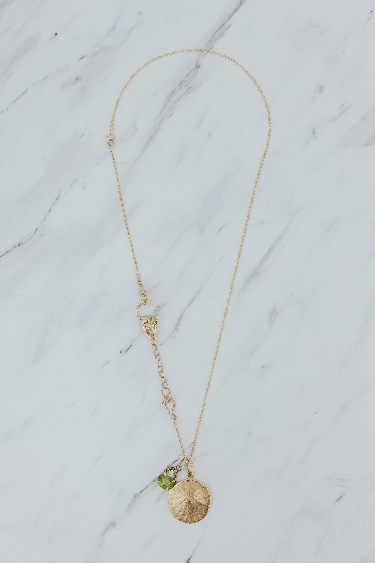Wings Hawaii The Boss Charm Collector necklace in solid 14k yellow gold. Hand grasping loop, sand dollar charm. Fine jewelry handcrafted in Maui. The ultimate statement piece in custom charm collecting. 
