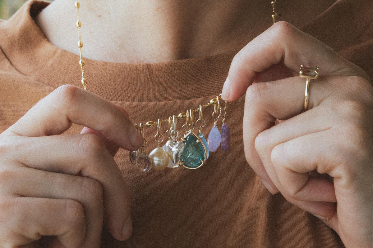 Hands holding a charm necklace
