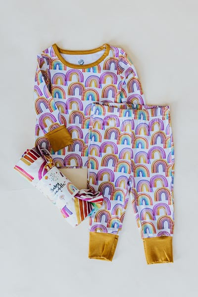 Wings Hawaii rainbow keiki pajamas  shown with rainbow baby swaddle