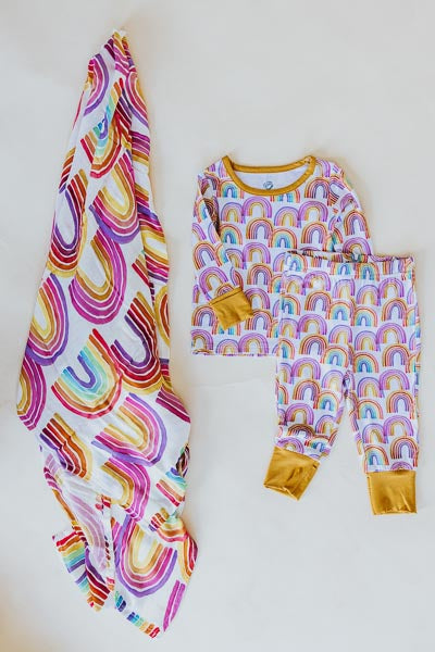 Wings Hawaii rainbow keiki pajamas shown with rainbow baby swaddle