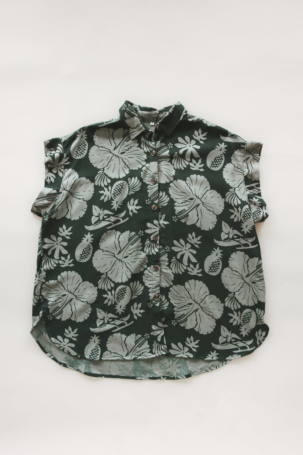 Wings Hawaii Short Sleeve Pocket Blouse in green Hana Forest aloha print with hibiscus flowers, pineapples and Hawaiian outrigger canoes. Modern women's aloha shirt. Original artwork designed in Maui, sewn in Bali. Small batch, sustainable apparel for beachy boho surfer style. 