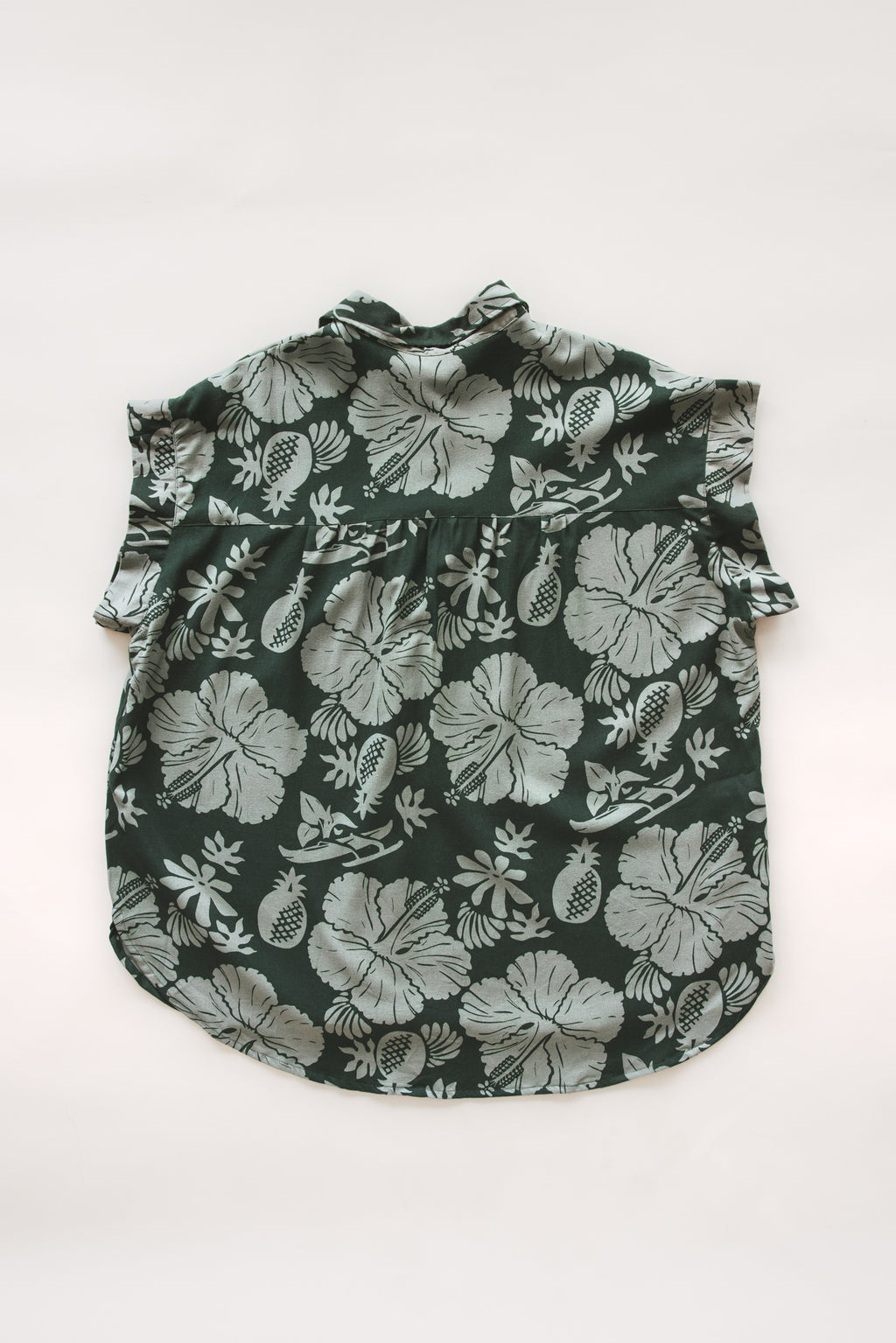 Wings Hawaii Short Sleeve Pocket Blouse in green Hana Forest aloha print with hibiscus flowers, pineapples and Hawaiian outrigger canoes. Modern women's aloha shirt. Original artwork designed in Maui, sewn in Bali. Small batch, sustainable apparel for beachy boho surfer style. 
