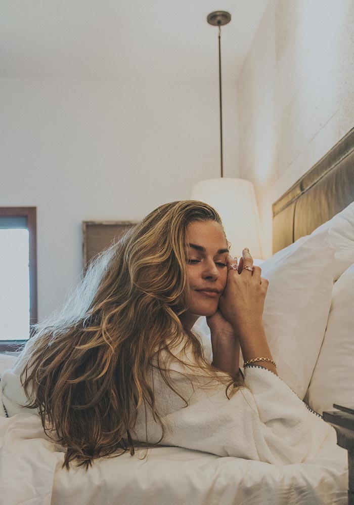 Model lying back on a bed