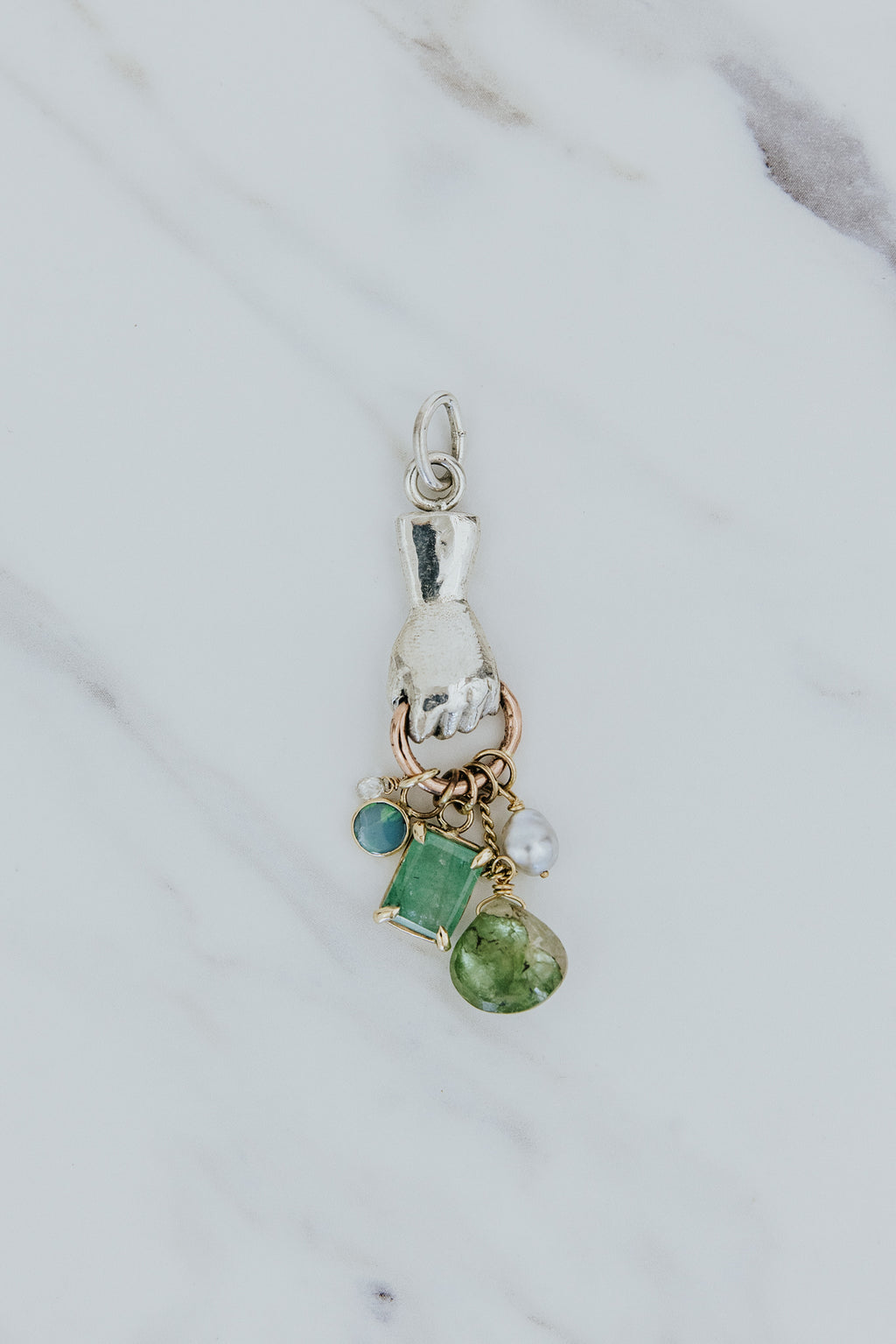 Wings Hawaii fine jewelry handmade in Maui. Necklace Charm hand holding gemstones. Mixed metals, sterling silver and 14k yellow gold. Emerald, tourmaline, diamond, opal, pearl. 