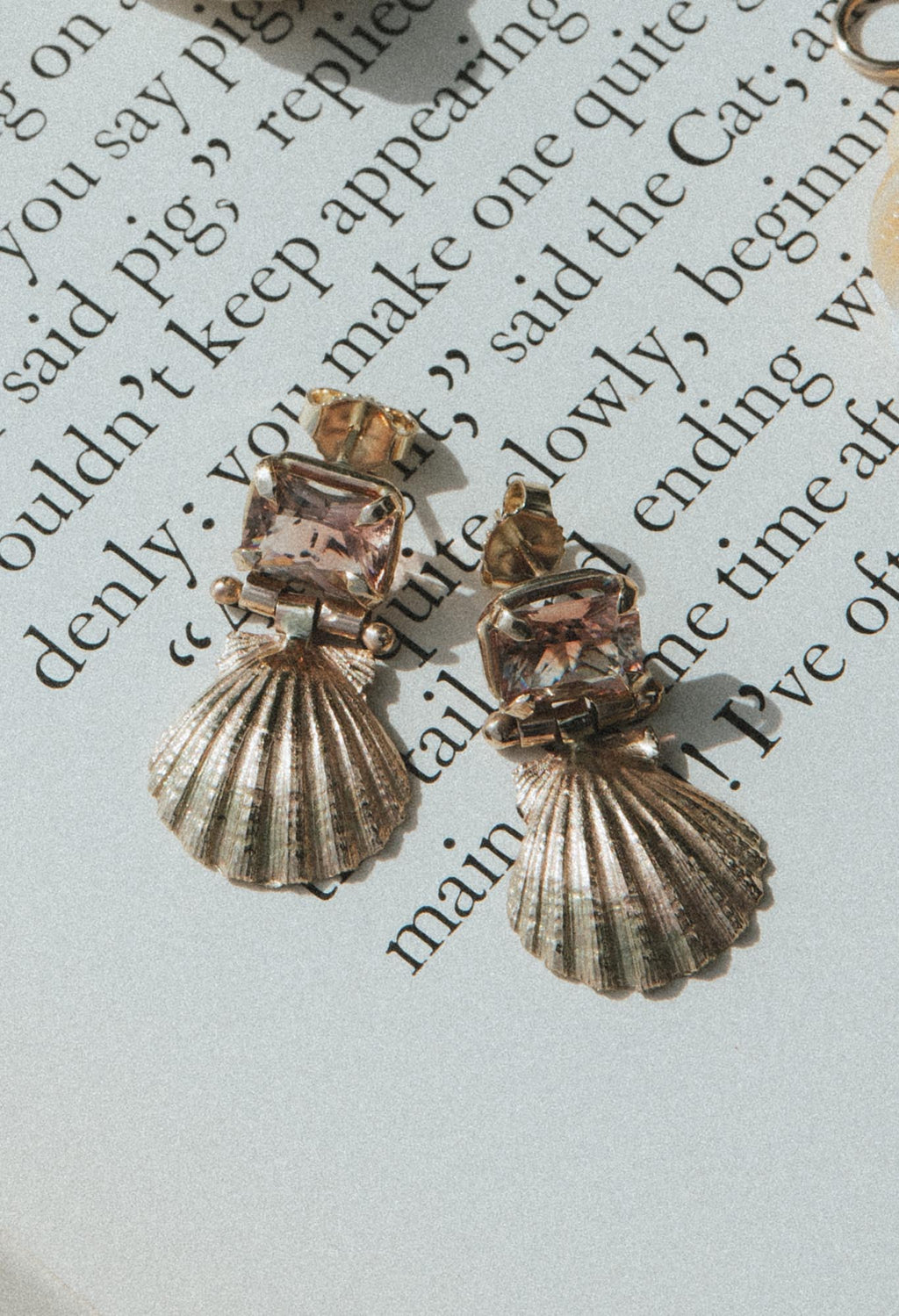 Wings Hawaii Siren Solstice Earrings with Red Schiller Sunstones and Sunrise Shells in solid 14k gold. Hinged for unique movement. Fine jewelry expertly handcrafted in Maui. 