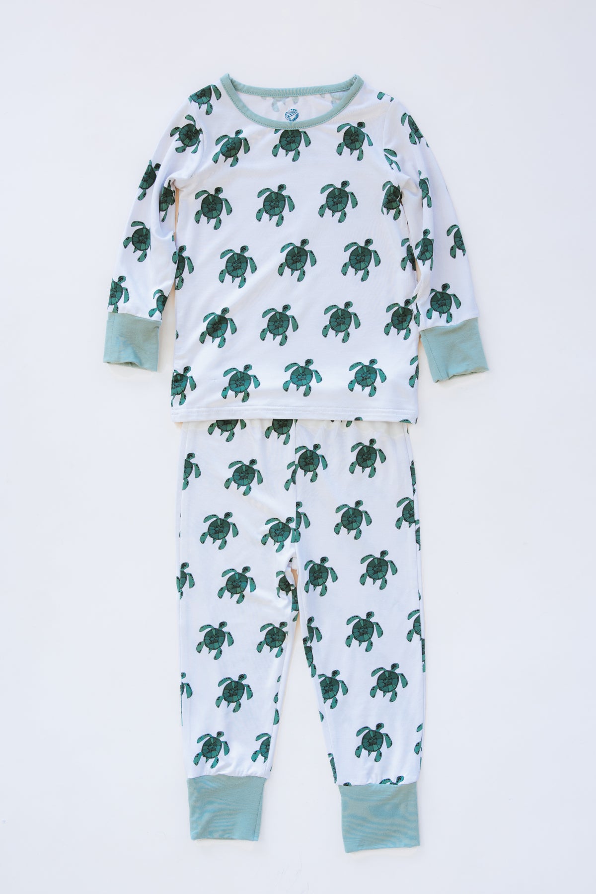 Wings Hawaii Honu kids pajamas set with sea turtles print. Original artwork designed in Maui. Island style keiki gifts. Long sleeved shirt with pajama pants. Small batch, sustainable, unique children’s apparel. 