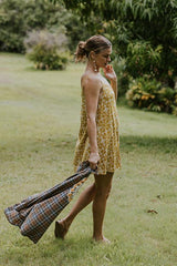 Wings Hawaii model wearing trapeze mini dress in ulu and plumeria print in marigold thumbnail