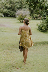 Wings Hawaii model wearing trapeze mini dress in ulu and plumeria print in marigold thumbnail