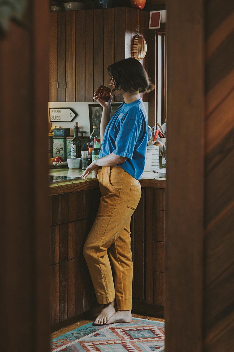 Model wearing Wings Hawaii retro pocket pants in marigold corduroy