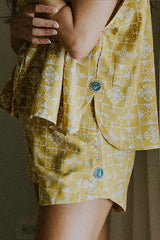 Model wearing Wings Hawaii retro pocket shorts and boxy buttun-up blouse in quilted ulu and plumeria print in marigold thumbnail