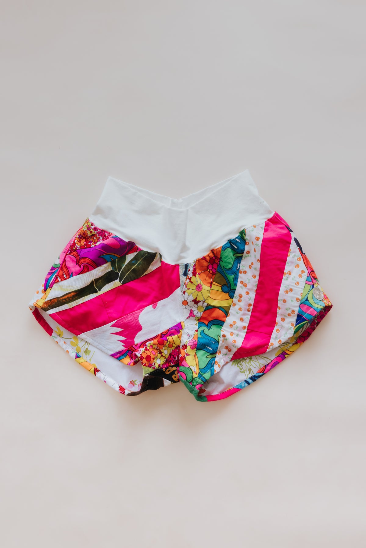Wings Hawaii Patchwork Pau Hana Shorts in Tropic Rush. Handmade, one of a kind, upcycled vintage quilt fabric. Stretchy cotton waistband and back pocket. Made with aloha in Maui. Sustainable, small batch, slow fashion. 