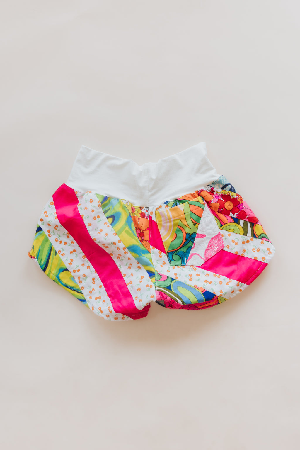 Wings Hawaii Patchwork Pau Hana Shorts in Tropic Rush. Handmade, one of a kind, upcycled vintage quilt fabric. Stretchy cotton waistband and back pocket. Made with aloha in Maui. Sustainable, small batch, slow fashion. 