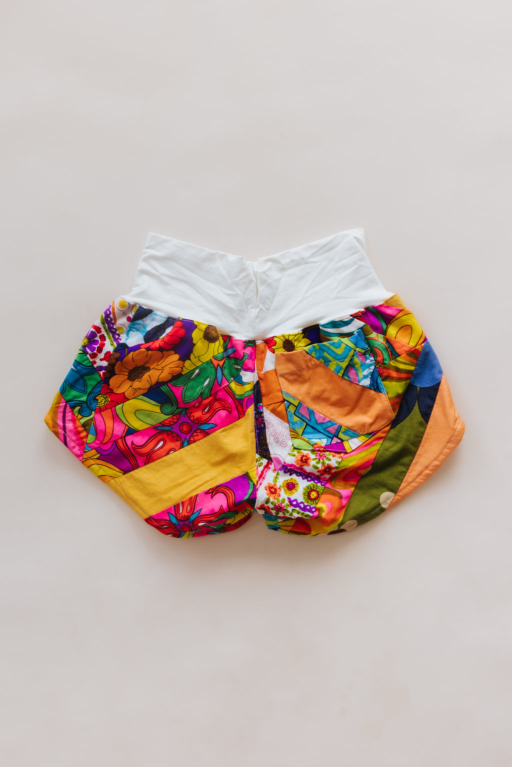 Wings Hawaii Patchwork Pau Hana Shorts in Tropic Rush. Handmade, one of a kind, upcycled vintage quilt fabric. Stretchy cotton waistband and back pocket. Made with aloha in Maui. Sustainable, small batch, slow fashion. 