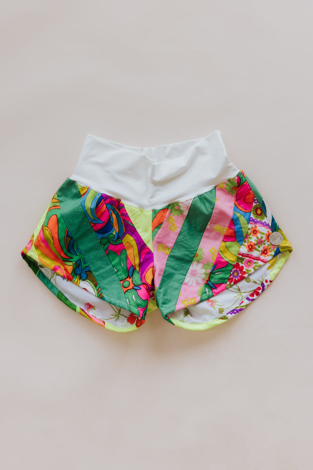 Wings Hawaii Patchwork Pau Hana Shorts in Tropic Rush. Handmade, one of a kind, upcycled vintage quilt fabric. Stretchy cotton waistband and back pocket. Made with aloha in Maui. Sustainable, small batch, slow fashion. 