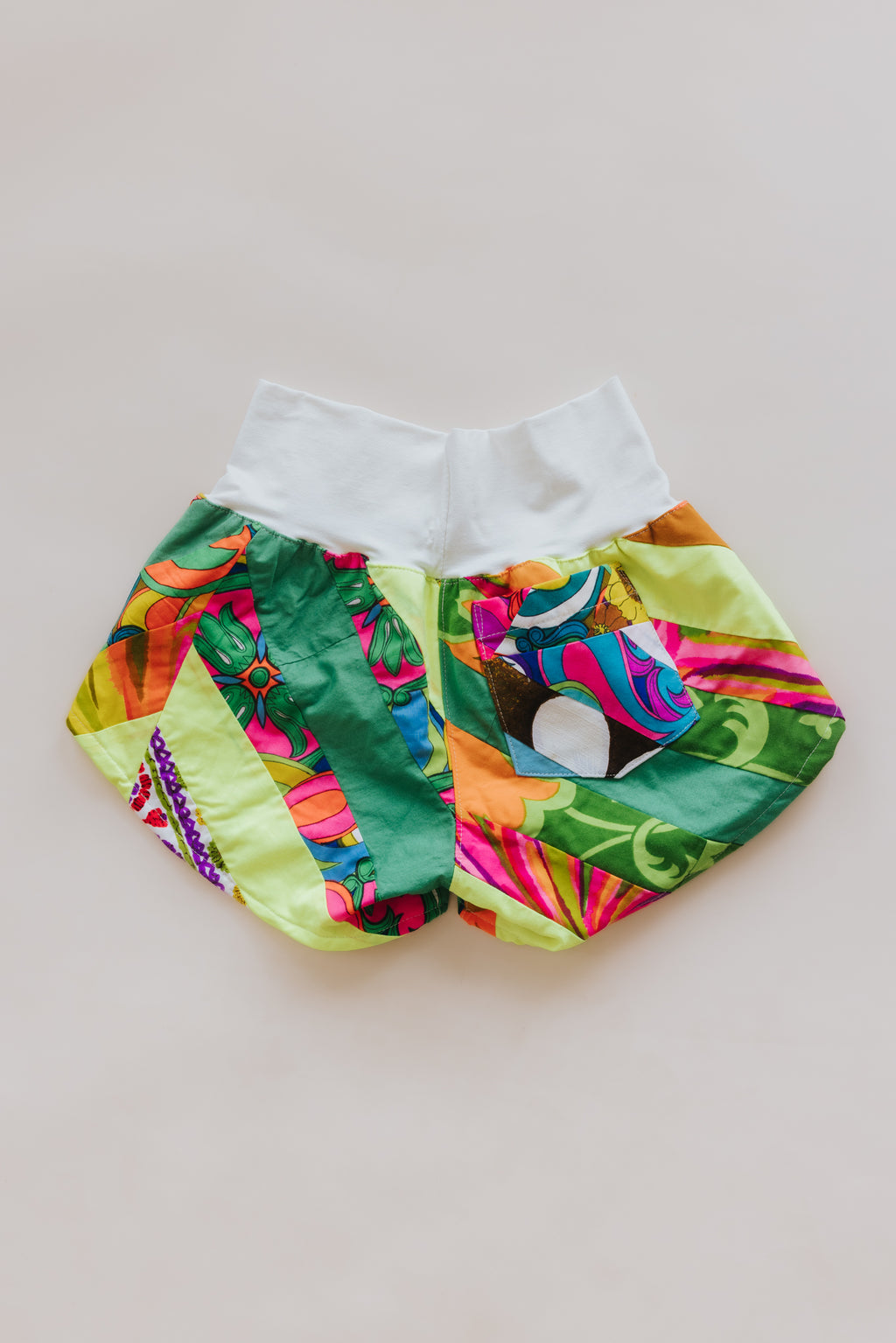 Wings Hawaii Patchwork Pau Hana Shorts in Tropic Rush. Handmade, one of a kind, upcycled vintage quilt fabric. Stretchy cotton waistband and back pocket. Made with aloha in Maui. Sustainable, small batch, slow fashion. 