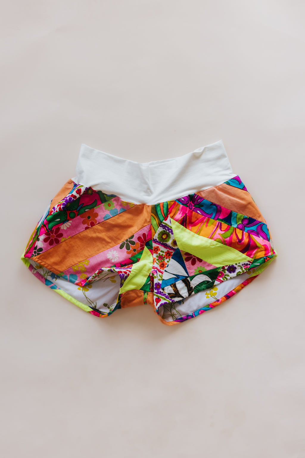 Wings Hawaii Patchwork Pau Hana Shorts in Tropic Rush. Handmade, one of a kind, upcycled vintage quilt fabric. Stretchy cotton waistband and back pocket. Made with aloha in Maui. Sustainable, small batch, slow fashion. 